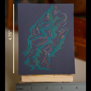May include: A colorful abstract print on dark blue paper, measuring 3.75 inches by 4.75 inches. The print features swirling lines in shades of teal, orange, and yellow.