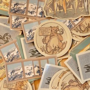 May include: A selection of stickers with diverse designs and text. Some stickers depict mountain scenes, fish, and a bear holding a sign saying "JESUS WANTS TO HEAR YOUR PROBLEMS TALK TO HIM ABOUT IT." Other stickers feature phrases such as "ALL GLORY BE".