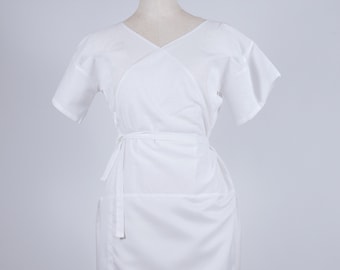 May include: A white wrap dress with short sleeves and a tie belt. The dress is made of a smooth, lightweight fabric.