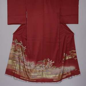 May include: A red silk kimono with a gold and white floral pattern. The kimono has a traditional Japanese design and is a beautiful example of Japanese craftsmanship.