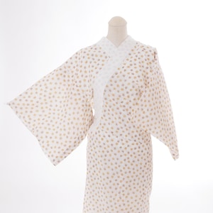 May include: A white kimono with a light brown star pattern. The kimono is folded and displayed on a white background.
