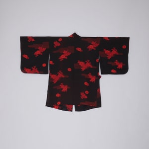 May include: A black kimono with a red floral pattern. The kimono has long sleeves and a wide collar.