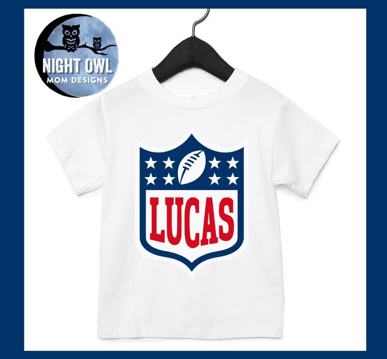 May include: White t-shirt with a blue and red football logo. The logo has stars and the name "LUCAS" in red.