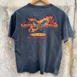 May include: Dark grey t-shirt with a graphic design featuring the text "HYPER YOYO" in orange and yellow, surrounded by flames. Below the graphic, the text reads "SUPER SPINNER: SPIN HARD OR DONT". The shirt is hanging on a wooden hanger.