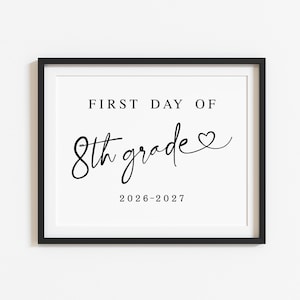 Op de afbeelding: Een zwart ingelijst bord met wit papier en zwarte tekst die luidt FIRST DAY OF 8th grade met een klein harticoontje aan het einde van het woord grade en het schooljaar 2026-2027 in een eenvoudig schreeflettertype onderaan in het midden.
