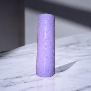 May include: A lavender-colored roller with a repeating pattern of white cats in various poses.