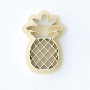 May include: A light beige pineapple-shaped object with a lattice design on the body and a leafy crown. The object is set against a white background, creating a clean and minimalist aesthetic. The pineapple design is a popular tropical motif.