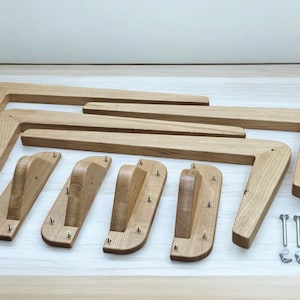May include: Set of six wooden table legs with a curved design. The legs are made of light brown wood and have a natural finish. The set also includes four metal screws and four metal washers.
