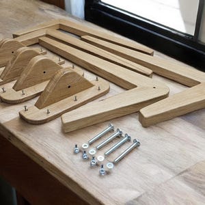 May include: Four unfinished wooden legs for a piece of furniture, with screws and nuts for assembly.