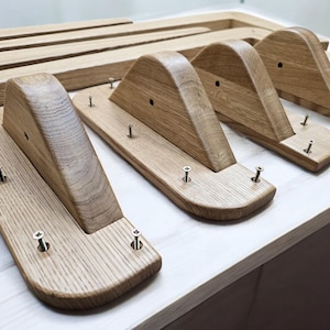 May include: Four wooden shelf brackets with a curved top and a flat bottom. Each bracket has several screws securing it to a wooden surface.
