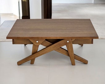 May include: A rectangular wooden coffee table with a natural finish. The table features a unique, angled leg design and a lower shelf. The table is approximately 48 inches long, 24 inches wide, and 16 inches high.