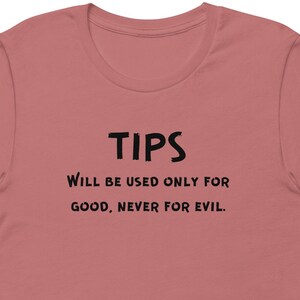 May include: A pink t-shirt with black text that reads "TIPS Will be used only for good, never for evil."