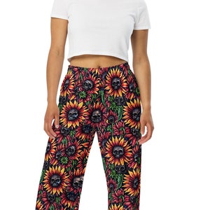 May include: A white crop top and black wide-leg pants with a sunflower and skull print.