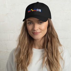 May include: A black baseball cap with an embroidered design of three flags. The flags are yellow, blue, and red with white checkered patterns.