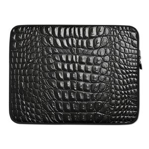 Puede incluir: Funda para portátil negra con estampado de piel de cocodrilo.