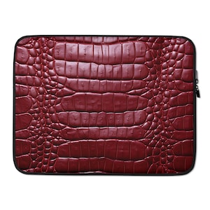 May include: Red laptop sleeve with a crocodile skin pattern.
