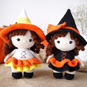 May include: Two crocheted Halloween witch dolls. One doll wears a black witch hat and a black and orange dress. The other doll wears a candy corn hat and a yellow, orange, and white dress.