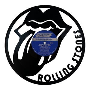 May include: A black vinyl record cut into the shape of the Rolling Stones' iconic tongue and lips logo. The record label is blue and white, with the text "LONDON STEREOHPHONIC". The words "ROLLING STONES" are cut out around the edge.