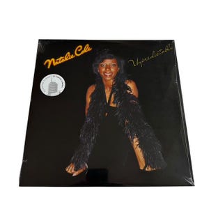 May include: Sealed vinyl record album of Natalie Cole's "Unpredictable". The album cover features a smiling woman in a black dress and a black feathered boa. The album title and artist's name are in gold lettering.