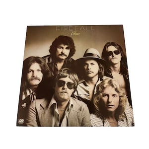 May include: Album cover for Firefall's "Elan" featuring a group of six men. The album art has a sepia tone with the band members in various shirts and jackets. The band name and album title are at the top.