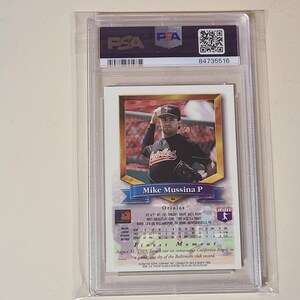 Puede incluir: Una tarjeta de b&eacute;isbol de Mike Mussina certificada por PSA en un estuche de pl&aacute;stico transparente. La tarjeta muestra una fotograf&iacute;a del lanzador con un uniforme negro de los Orioles, con el texto Mike Mussina P, Orioles y Finest Moment.