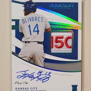 May include: A baseball card featuring Edward Olivares, a Kansas City Royals player. The card is from the Immaculate Collection and is numbered 15/50. The card features a photo of Olivares in his uniform, his autograph, and a patch with his number 14 on it.