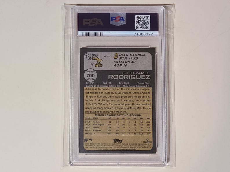 May include: A baseball card encased in a protective holder. The card features text about Julio Rodriguez, including his name, statistics, and a Topps logo. The card is graded and authenticated by PSA.