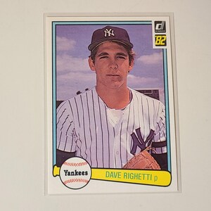 May include: A 1982 Donruss baseball card featuring Dave Righetti of the New York Yankees. The card shows Righetti in his pinstriped uniform and Yankees cap. The card has a yellow and white border with the Yankees logo and Righetti's name.