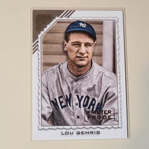 May include: A baseball card featuring Lou Gehrig in a New York Yankees uniform. The card has a sepia-toned image of Gehrig wearing a cap with the NY logo. The words "NEW YORK" are across the front of the jersey. The card is labeled "PRINTER PROOF".