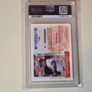 May include: A baseball card in a clear plastic case. The card shows Mike Piazza in a Dodgers uniform. The card is labelled "Baseball's Finest" and "199". The case has a PSA label and a serial number.