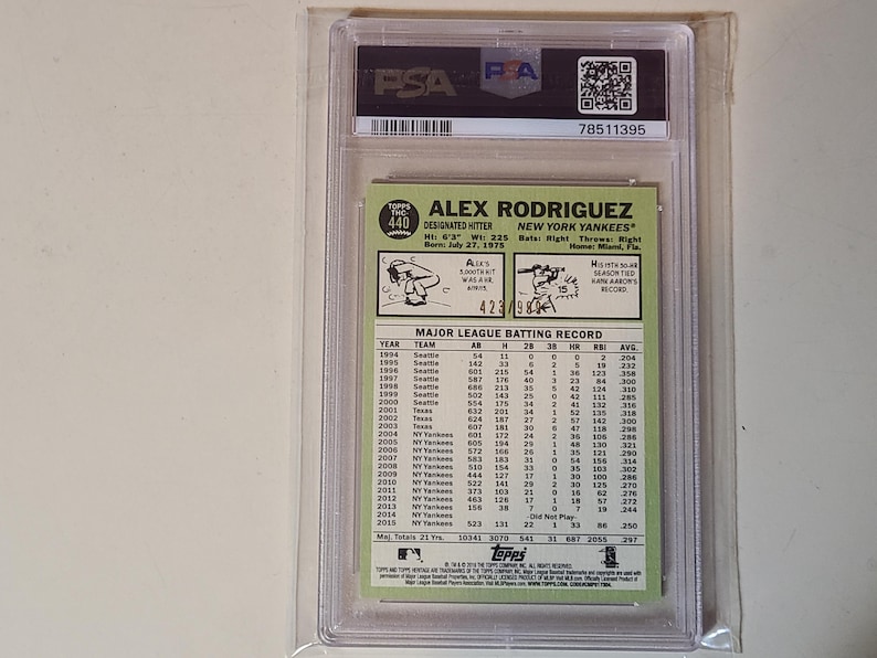 May include: A baseball card of Alex Rodriguez, graded and encased by PSA. The card features a photo of Rodriguez and his stats, including his height of 6'3" and weight of 225 lbs. The card is from the Topps series.