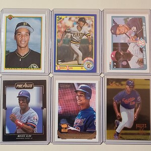 May include: Six baseball trading cards featuring different players. The cards are in plastic sleeves and are arranged in two rows of three. The cards feature players from the Pirates, Expos, and Braves. The cards are all from the 1990s.