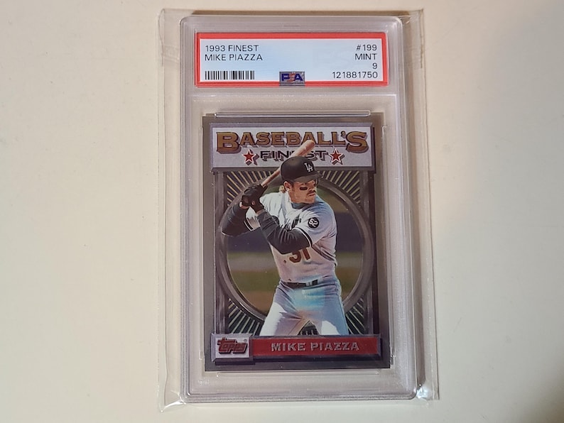 May include: A graded 1993 Finest Mike Piazza baseball card in a protective case. The card shows a player image and the text "Baseball's Finest". The top of the case has the text "1993 Finest Mike Piazza".