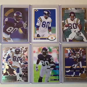 May include: Six football trading cards featuring Cris Carter in a Minnesota Vikings uniform. The cards display action shots of Carter in various poses, with the number 80 prominently visible. The cards are encased in protective sleeves.