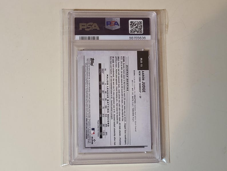 May include: A baseball card of Aaron Judge, New York Yankees outfielder, encased in a clear protective holder. The card features the Topps logo and MLB-15. The holder has a PSA label with a barcode and serial number.