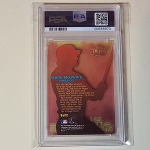 May include: A baseball card encased in a protective holder. The card features a silhouette of a baseball player in a batting stance, with the name "MARK MCGWIRE" and the Athletics team logo. The card is graded by PSA.