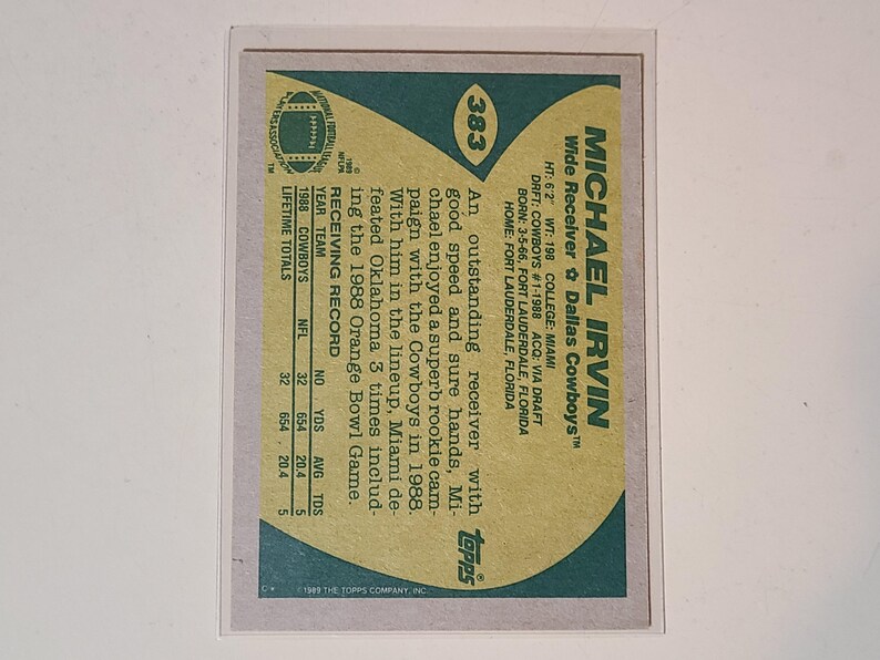 May include: A vintage Michael Irvin football card from the 1988 Topps series. The card features a green and tan design with player stats and biographical information. The card is in a protective sleeve.