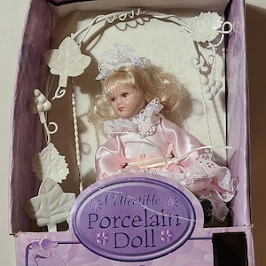 4 inch Porcelain Girl Doll on a swing (Brand New and Sealed **Box may have damage**