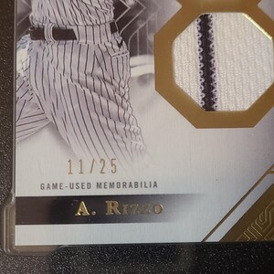 May include: A baseball card with a player in a pinstripe uniform. The card includes a fabric patch and the text "GAME-USED MEMORABILIA." The card is numbered 11/25 and has the player's name, A. Rizzo, at the bottom.