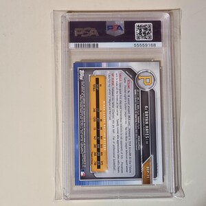 Puede incluir: Una tarjeta de b&eacute;isbol de Ke'Bryan Hayes, dentro de un soporte de pl&aacute;stico transparente. La tarjeta presenta el logotipo de los Piratas de Pittsburgh y la informaci&oacute;n del jugador. La tarjeta est&aacute; calificada por PSA, con un n&uacute;mero de serie visible.