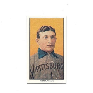 May include: A vintage baseball card featuring a portrait of a man wearing a gray baseball uniform with the word "PITTSBURG" printed on the front. The card has a yellow background and the text "WAGNER, PITTSBURG" printed at the bottom.