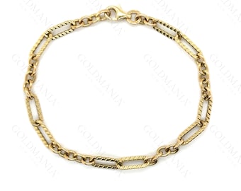 Peut inclure: Un bracelet doré avec un mélange de maillons rectangulaires et ovales. Les maillons rectangulaires présentent un motif texturé en forme de corde, tandis que les maillons ovales sont lisses. Le bracelet est sécurisé par un fermoir mousqueton.