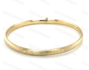 Puede incluir: Un brazalete de oro con un delicado diseño floral grabado.