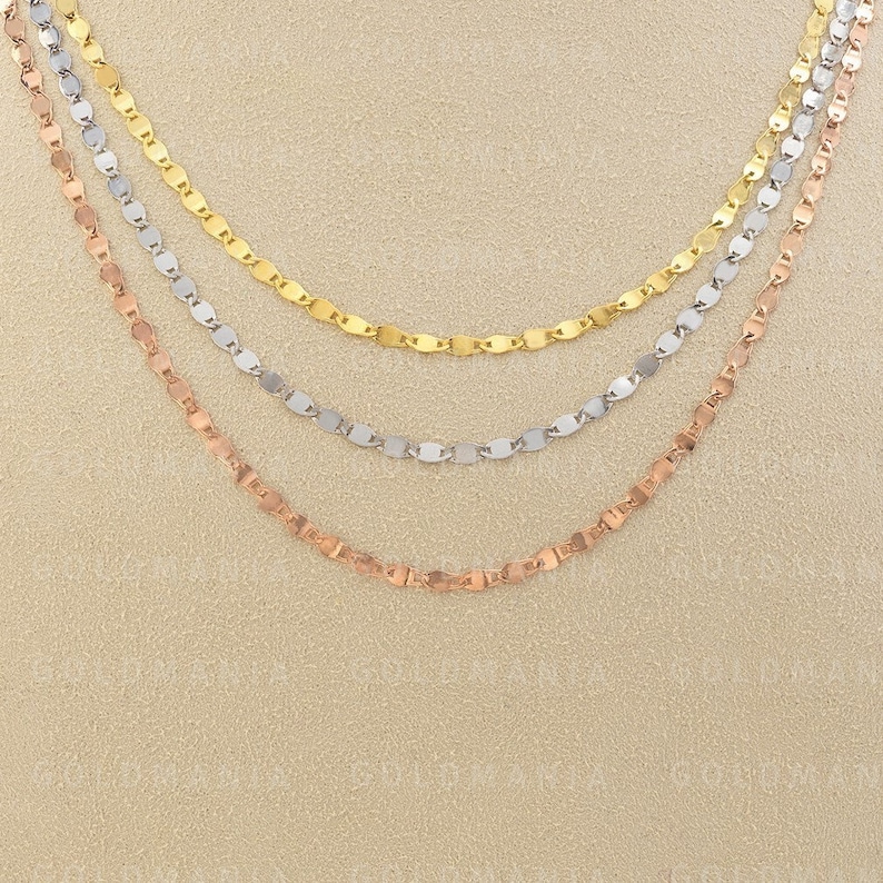 May include: Three layered necklaces with a delicate chain design. The top layer is gold, the middle layer is silver, and the bottom layer is rose gold.