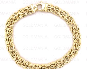 Puede incluir: Un brazalete de cadena de oro con un patrón de eslabón de estilo bizantino.
