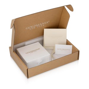 Puede incluir: Caja de cart&oacute;n abierta que contiene una caja de joyer&iacute;a blanca, una peque&ntilde;a bolsa de color crema y una tarjeta. La caja y la tarjeta presentan el texto "GOLDMANIA NEW YORK" en fuente plateada. El interior est&aacute; forrado con papel de seda blanco.