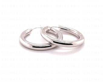 May include: A pair of polished silver hoop earrings with a smooth, rounded surface. The earrings feature a classic circular design with a reflective metallic finish, showcasing a simple and clean aesthetic suitable for various jewelry collections.