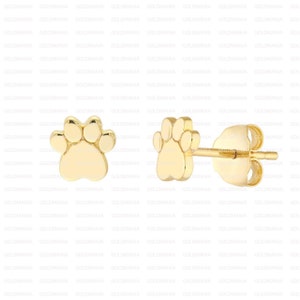 May include: A pair of gold-tone paw print stud earrings. The earrings are small and delicate, and they would make a great gift for a dog lover.
