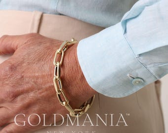 May include: A gold chain bracelet with a chunky link design. The bracelet is worn on a person's wrist. The brand name "GOLDMANIA NEW YORK" is visible on the bottom of the image.