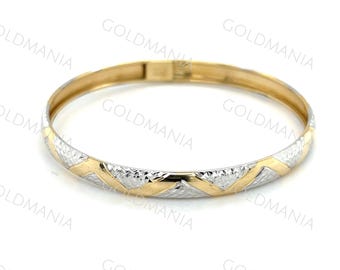 May include: A gold bangle bracelet with a two-tone design. The bracelet features a repeating pattern of gold and silver-colored chevrons around the band. The bracelet is circular and has a clasp.